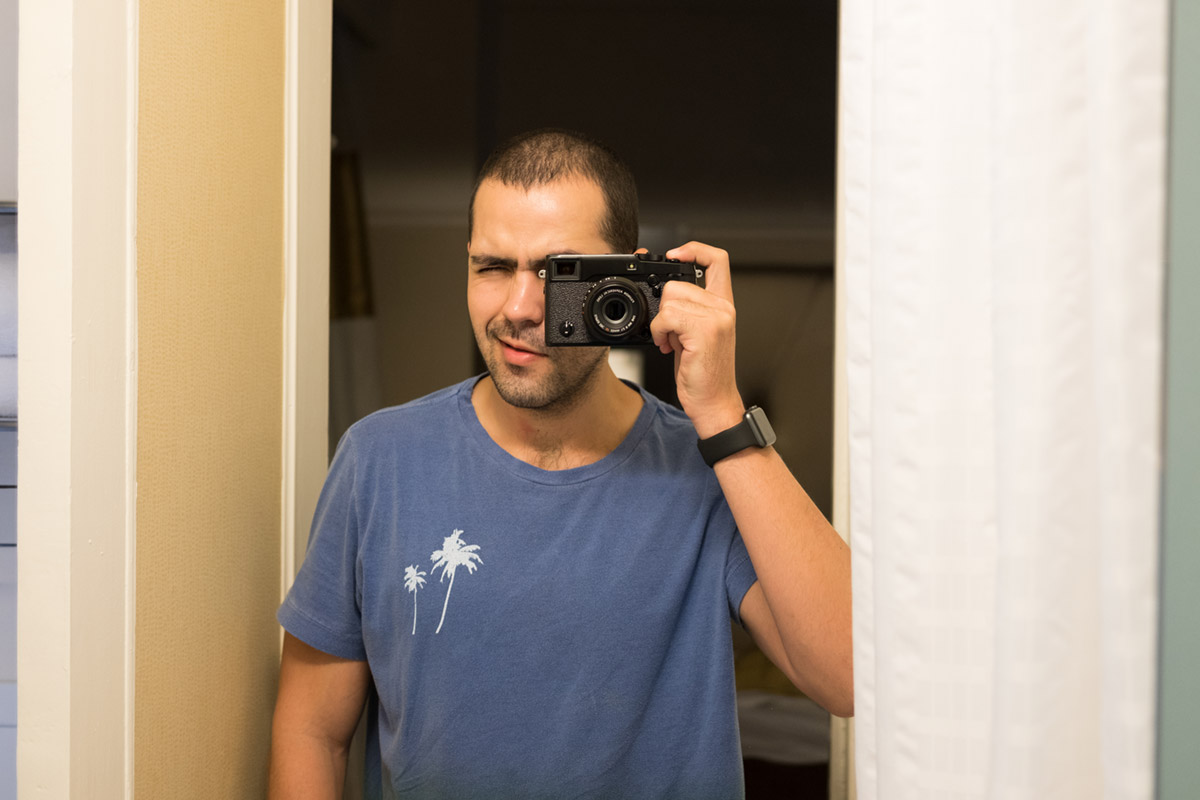 “Auto-retrato” com a XF 35mm f/2 R WR em f/2 1/60 ISO500; note como o “estilo rangefinder” tira a câmera da frente do rosto do fotógrafo.